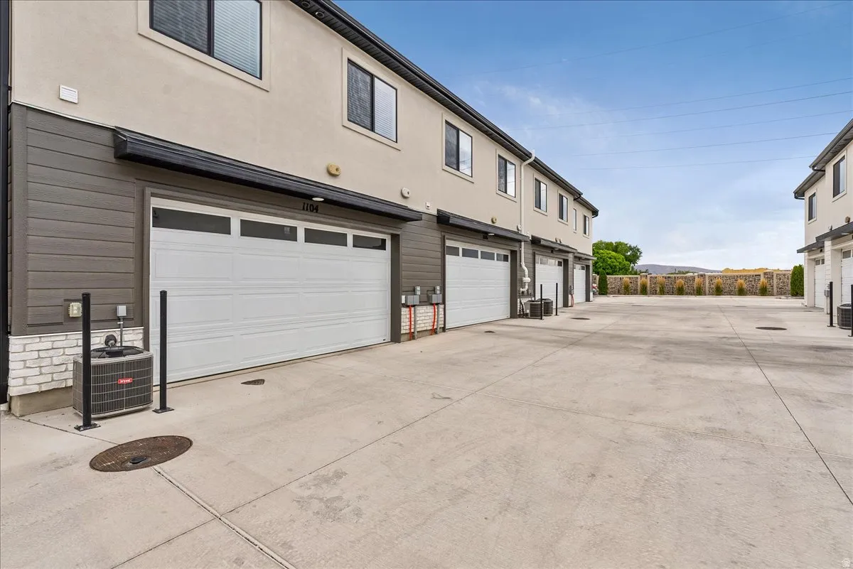 Modern townhome exterior with a light stucco finish and dark horizontal siding