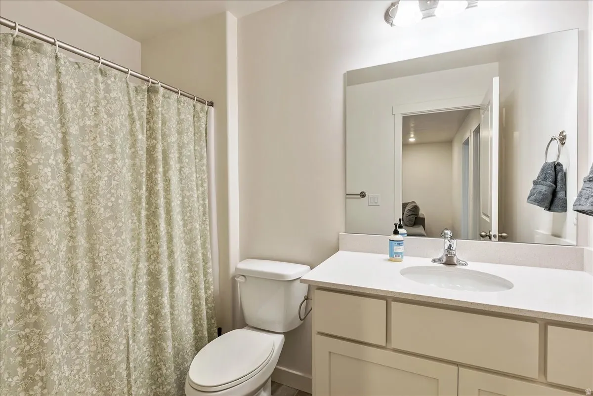 Bathroom with a single vanity, undermount sink, and light-toned countertop