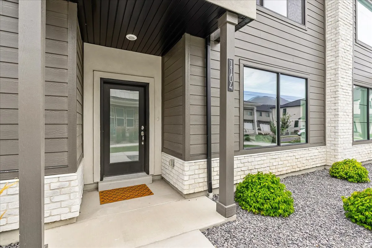 Contemporary exterior featuring horizontal siding in a neutral tone, complemented by a white brick facade
