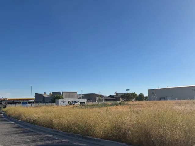 Expansive undeveloped land featuring natural grasses and a clear sky backdrop