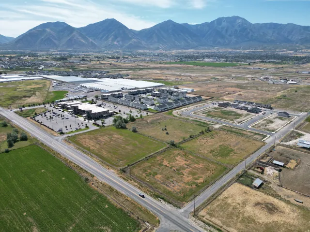 Expansive land parcel with surrounding agricultural fields, new residential developments, and commercial structures