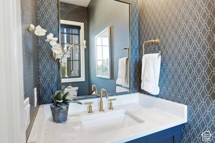 Vanity with integrated sink, white countertop, and gold-finish faucet