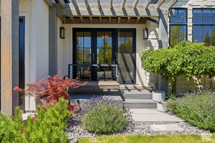 Contemporary exterior featuring board and batten siding, stone facade, and a decorative wood pergola