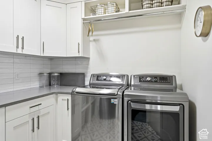 Laundry area featuring white shaker-style cabinetry with brushed nickel hardware, light gray countertops, and a white subway tile backsplash