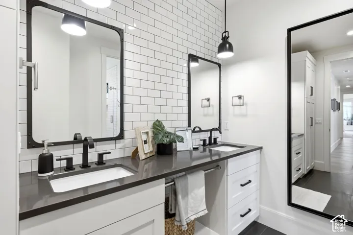 Dual vanity with undermount sinks, dark countertops, and matte black fixtures