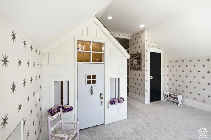 Custom-built interior playhouse featuring shingle siding, a white entry door with a divided light window, and a window box