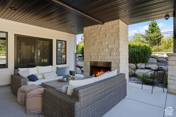 Covered patio featuring a stone-clad fireplace with a modern insert