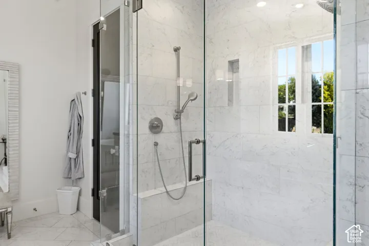 Walk-in shower featuring clear glass enclosure, a built-in niche, and dual shower heads