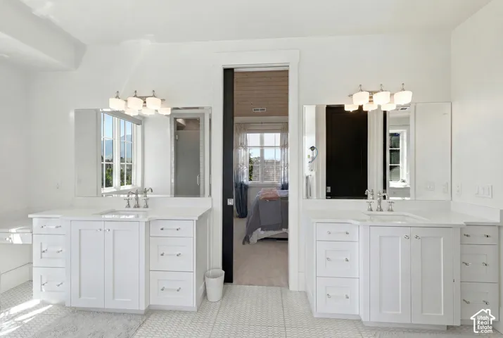Dual vanities with white cabinetry, quartz countertops, and brushed nickel fixtures