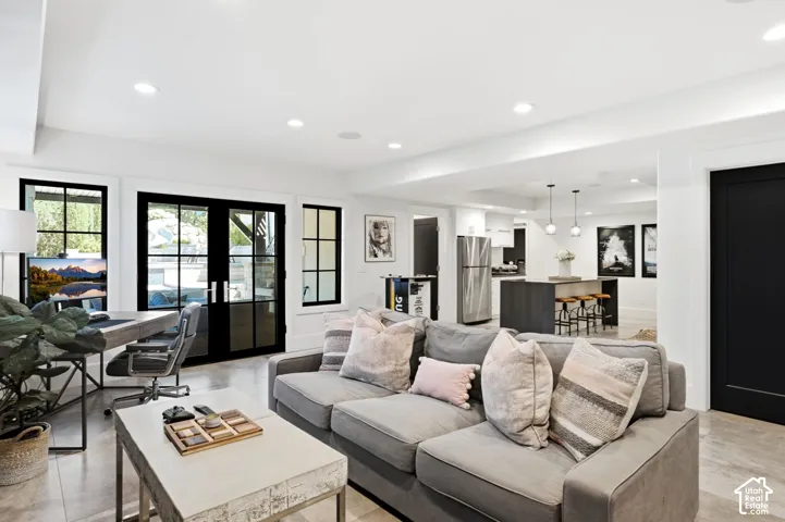 Open-concept living area featuring recessed lighting, large French doors with sidelight windows, and light-toned flooring
