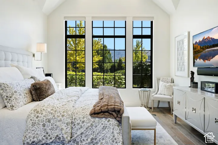Vaulted ceiling bedroom with a triple window array featuring black muntin bars