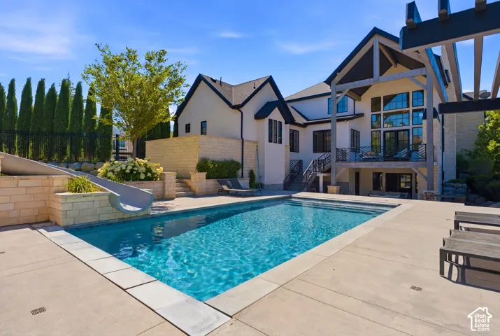 Rectangular in-ground swimming pool with a concrete surround and stone coping