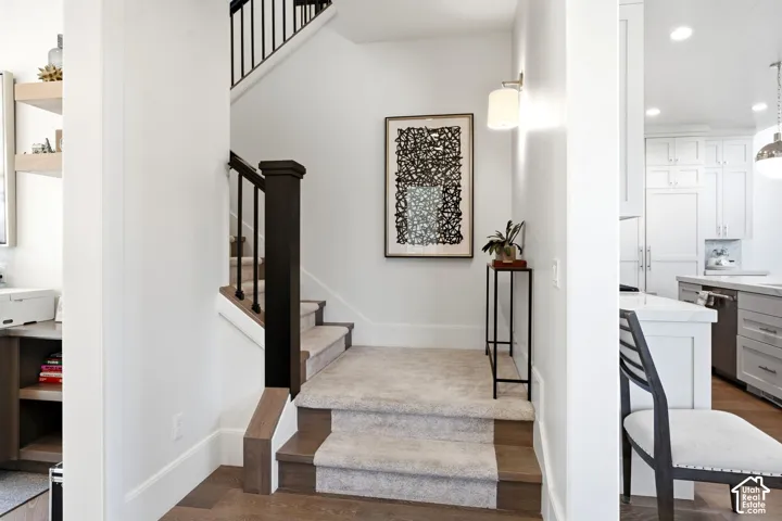 Staircase featuring dark wood newel posts and railings with black metal balusters