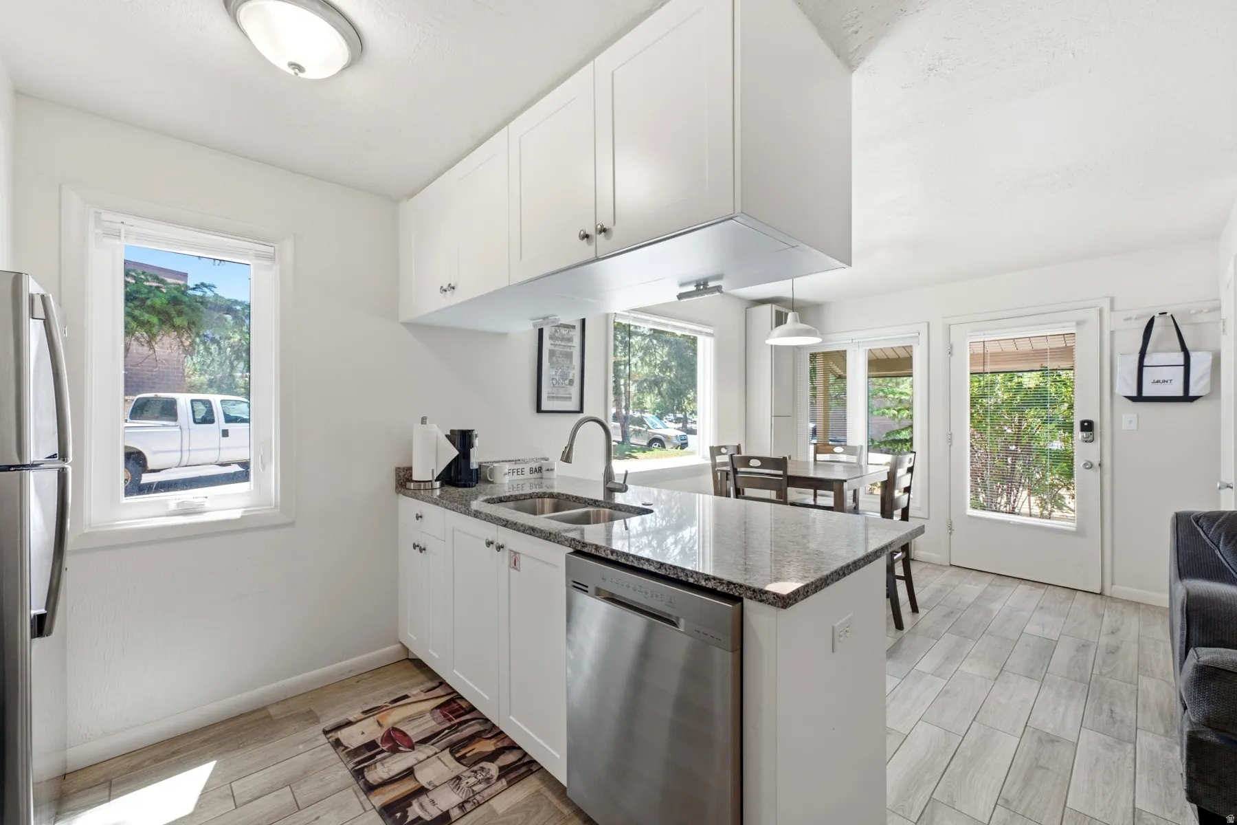 Kitchen featuring white cabinetry, stainless steel appliances, and granite countertops
