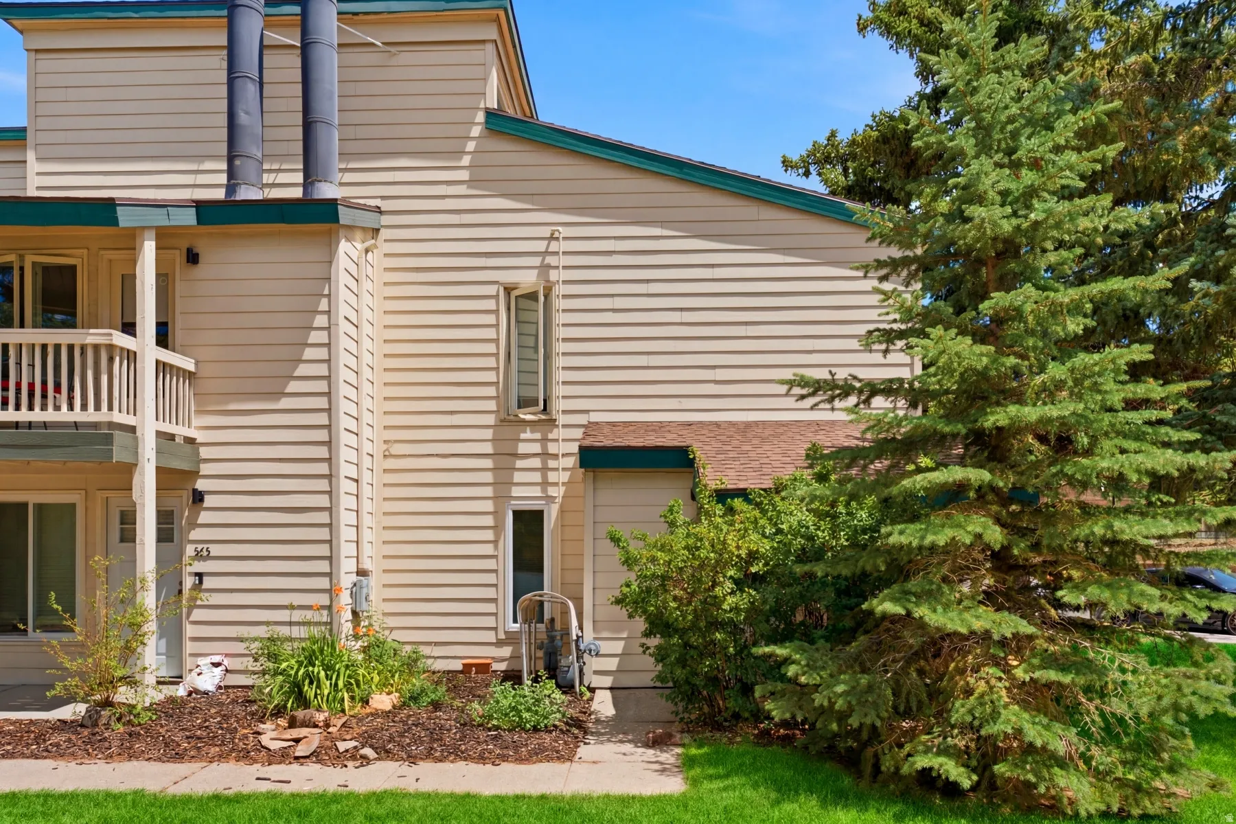 Exterior siding in a neutral tone with contrasting dark green trim