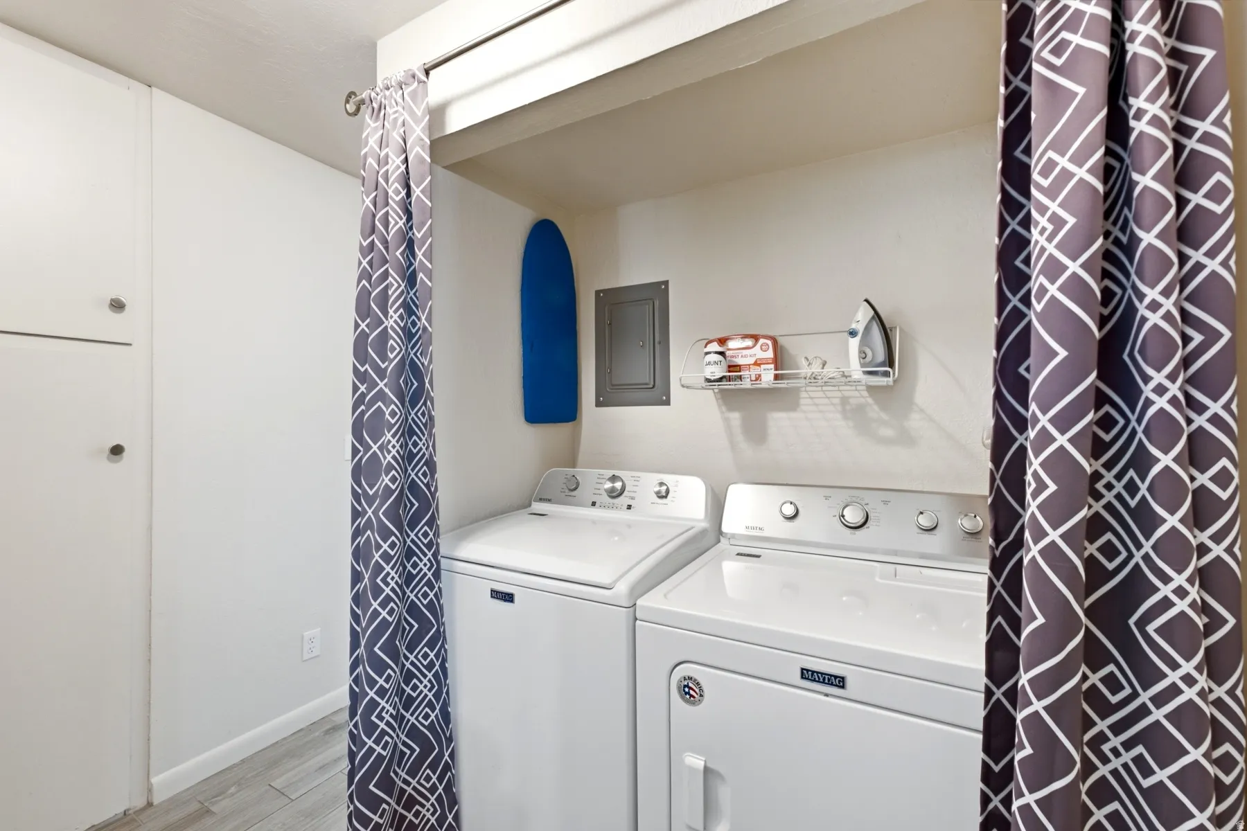 Dedicated laundry area featuring a washer and dryer, built-in storage cabinetry, and durable tile flooring