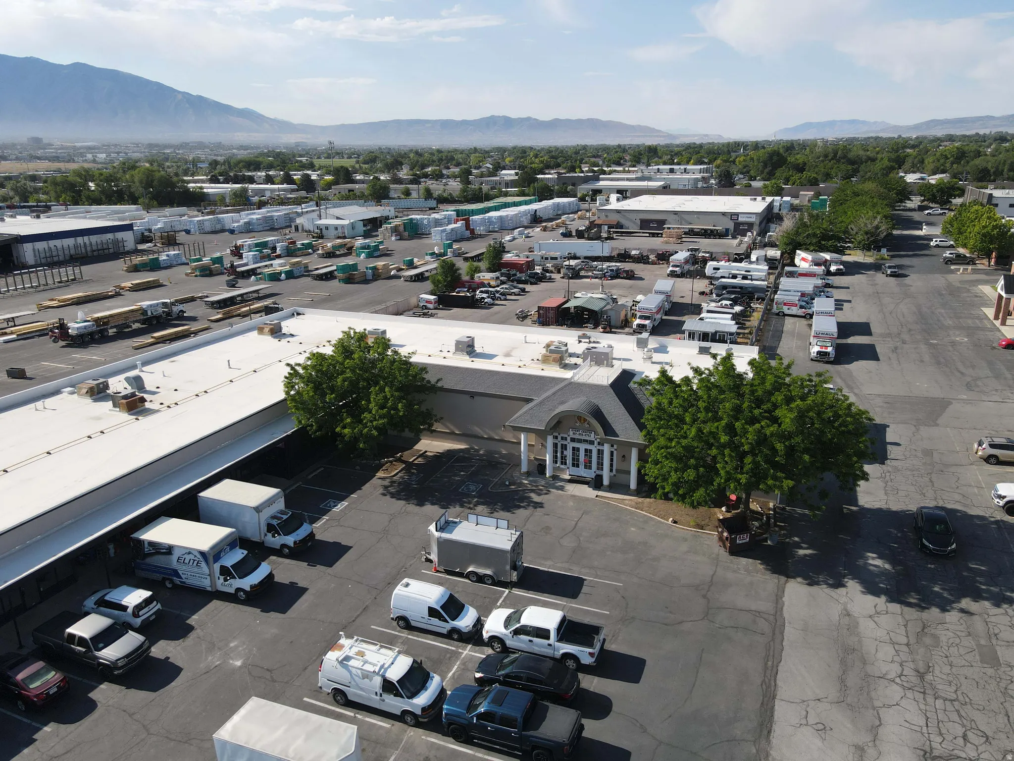 Commercial property featuring a large paved parking lot and multiple industrial buildings