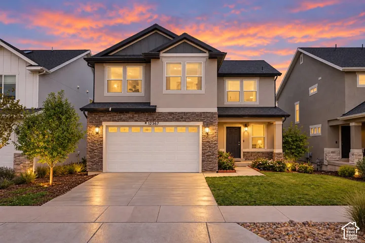 Two-story residence featuring a mixed-material exterior, attached two-car garage, and a covered front entry