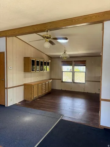 Spacious room featuring wood-finish flooring, a built-in cabinetry unit, and large windows