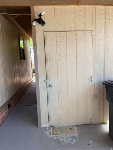 Exterior utility door featuring a latch and knob hardware
