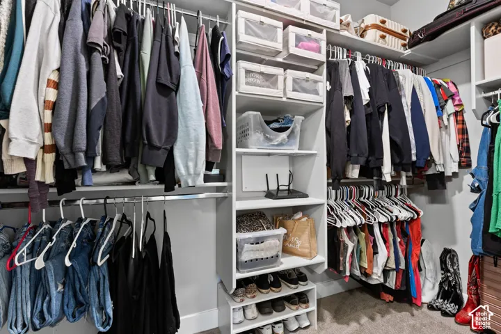 Built-in closet system featuring multiple hanging rods, open shelving, and integrated shoe storage