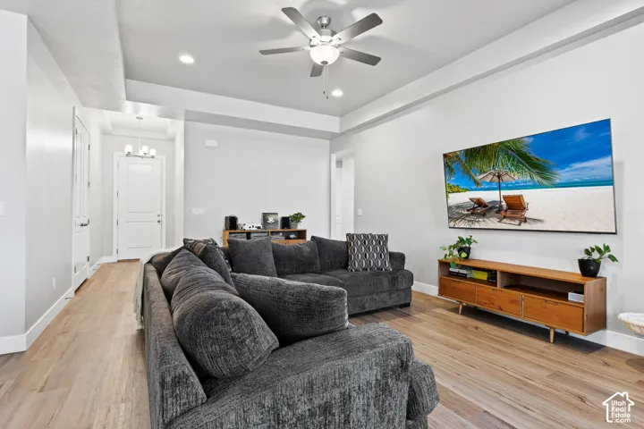 Open-concept living space featuring wood-finish flooring, recessed lighting, a ceiling fan, and a light-toned interior paint scheme