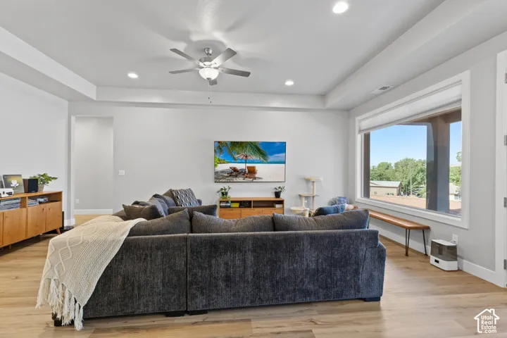 Spacious living area featuring wood-finish flooring, recessed lighting, and a ceiling fan