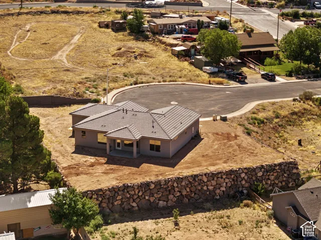 Contemporary single-story residence featuring a covered front entry, light-toned stucco exterior, and a tiled hip roof