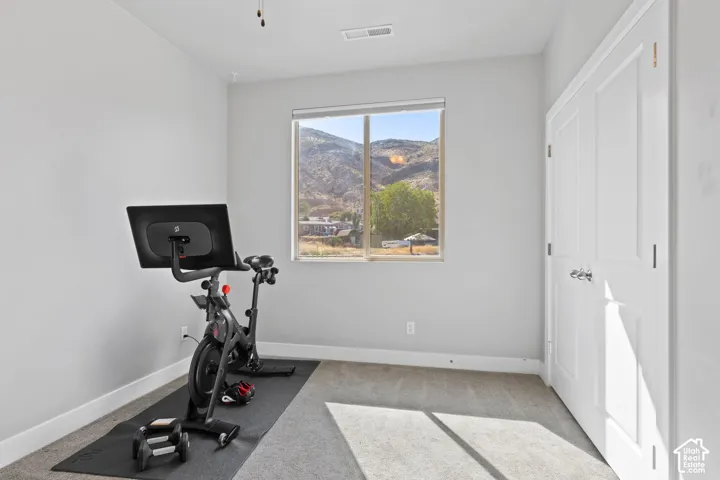 Room with light gray walls, an operable window, and light gray carpeted flooring
