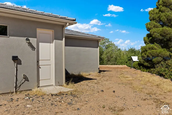 Stucco exterior with a tan paneled door and outdoor wall lantern