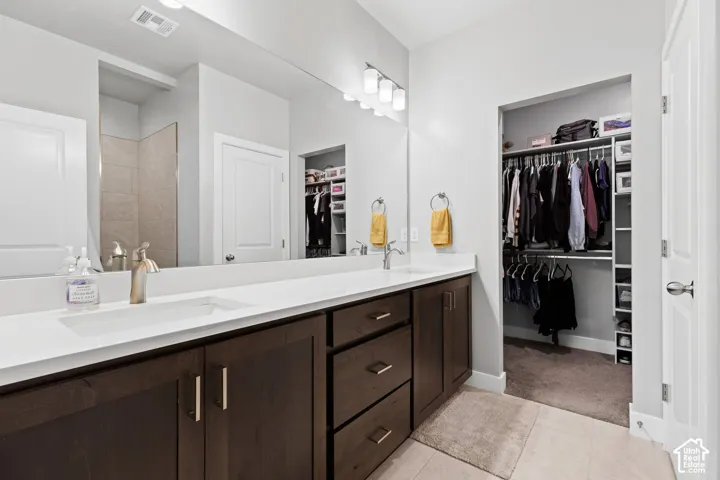 Double vanity with rectangular undermount sinks, bronze finish faucets, and white countertops