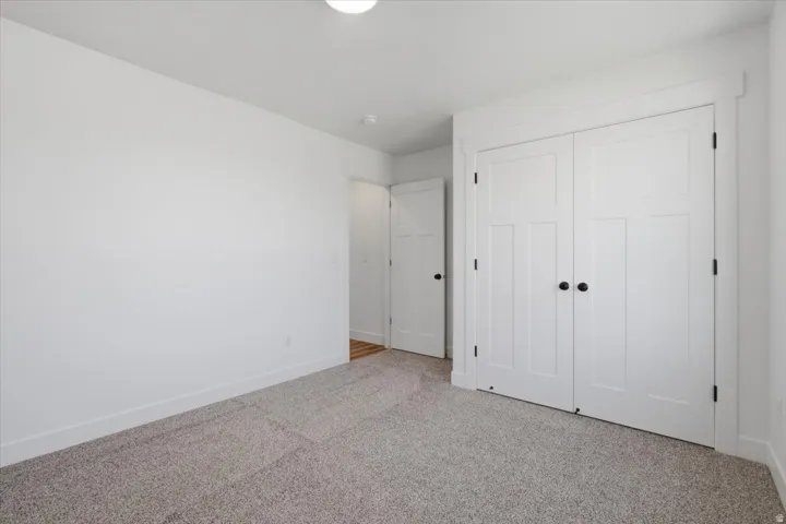 Neutral-toned carpeting, white walls, and white trim throughout