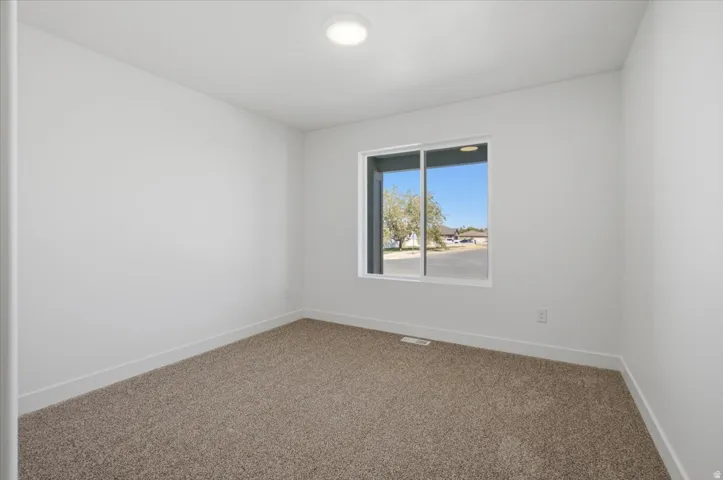 Recessed ceiling light, white walls, carpeted flooring, large window, white trim
