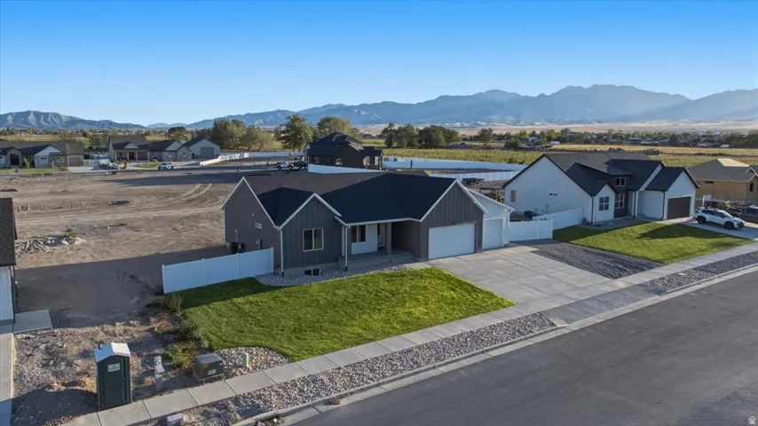 Contemporary-style residence with dark gray siding, an attached two-car garage, and a concrete driveway