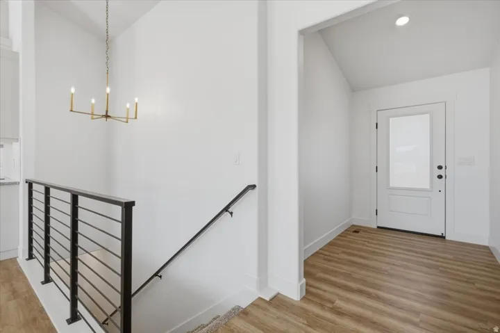 Staircase featuring modern horizontal metal railings and a black handrail