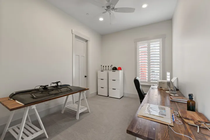 Neutral-toned room featuring a window with white plantation shutters, recessed lighting, and a ceiling fan