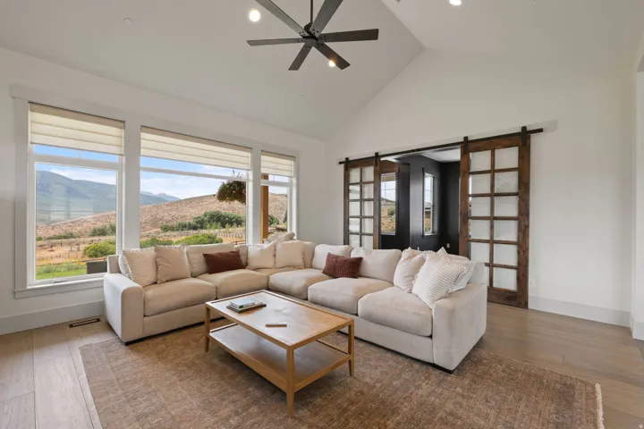 Spacious living area featuring vaulted ceilings, recessed lighting, and wood-finish flooring