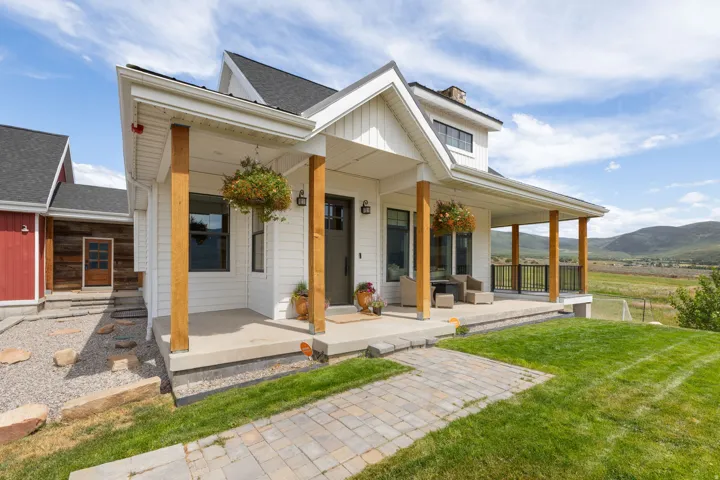 White farmhouse-style exterior with a covered porch and wood-tone support columns