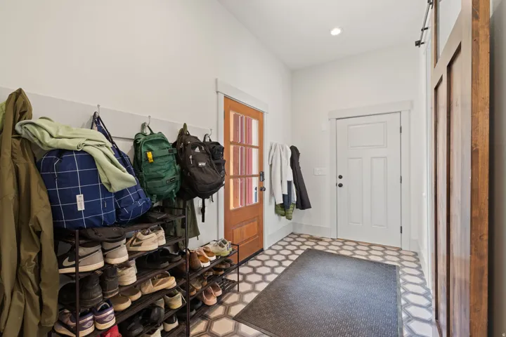 Entryway featuring hexagonal floor tiling, a paneled door, and a rich wood-tone door with glass inserts