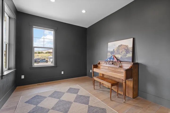 Room featuring light wood-finish flooring, dark gray walls, and white recessed lighting