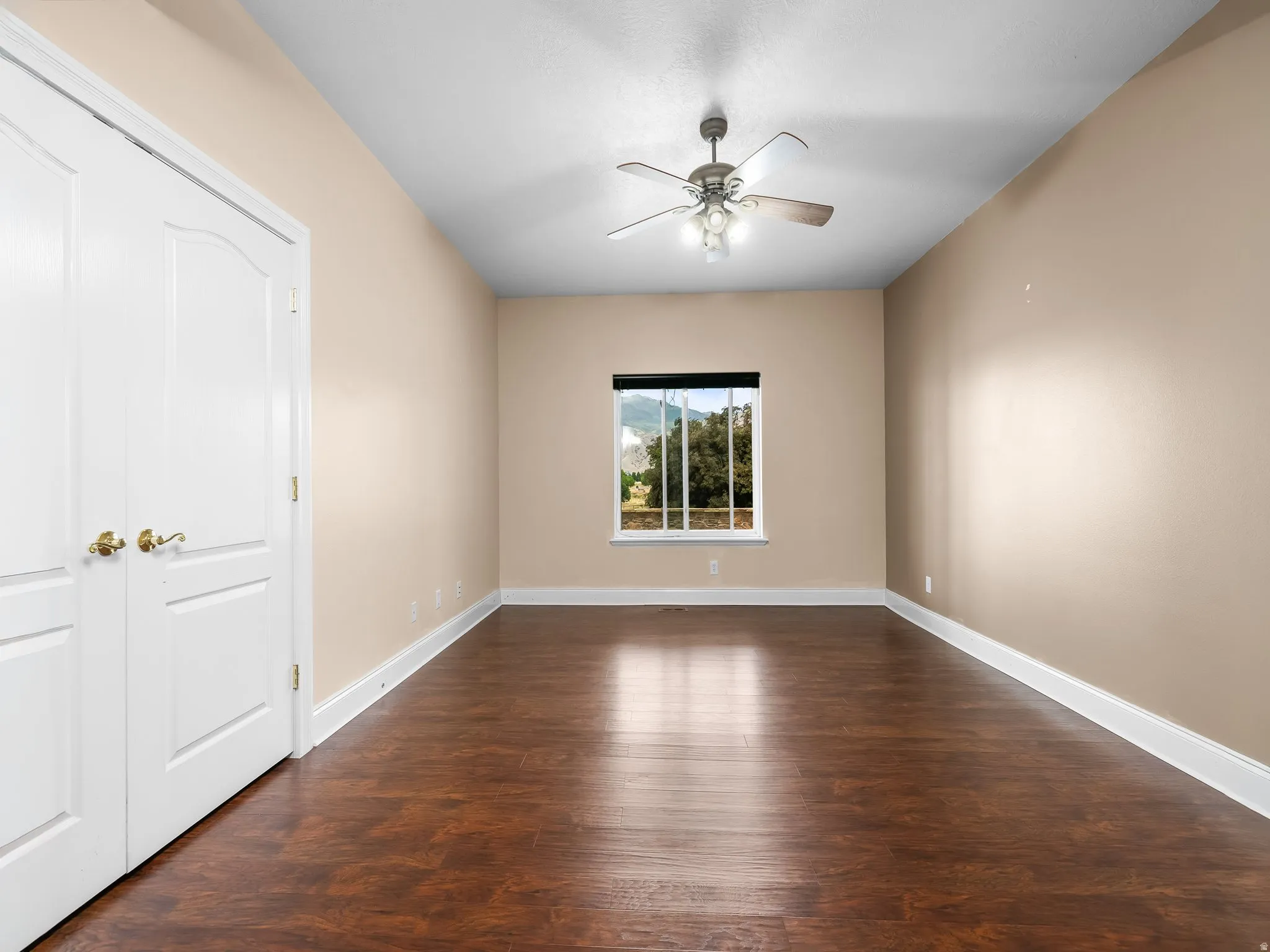 Room featuring wood-finish flooring, neutral wall paint, and white baseboards