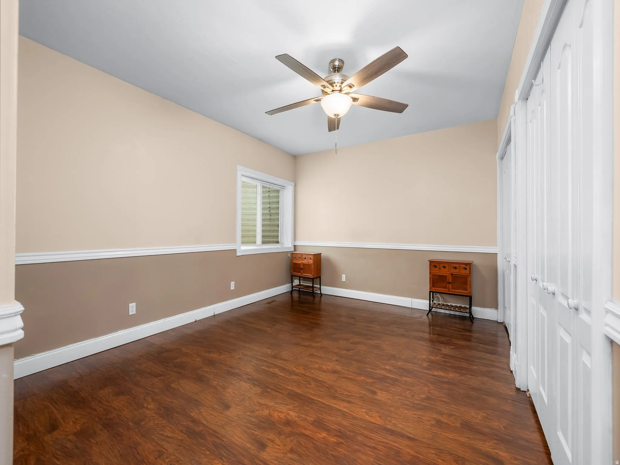 Rich wood-finish flooring complements the two-tone wall treatment with chair rail molding