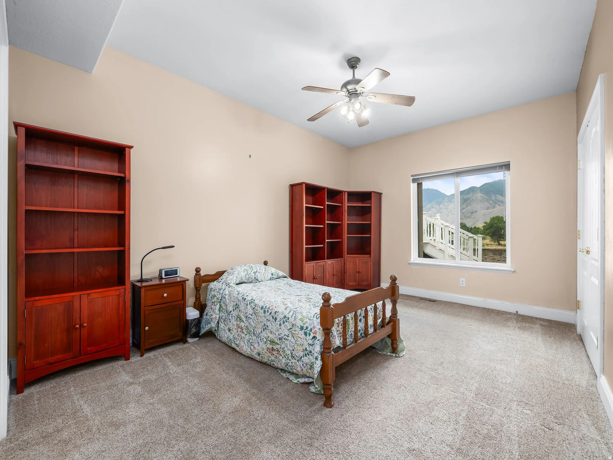 Spacious room featuring vaulted ceilings, a ceiling fan, and carpeted flooring