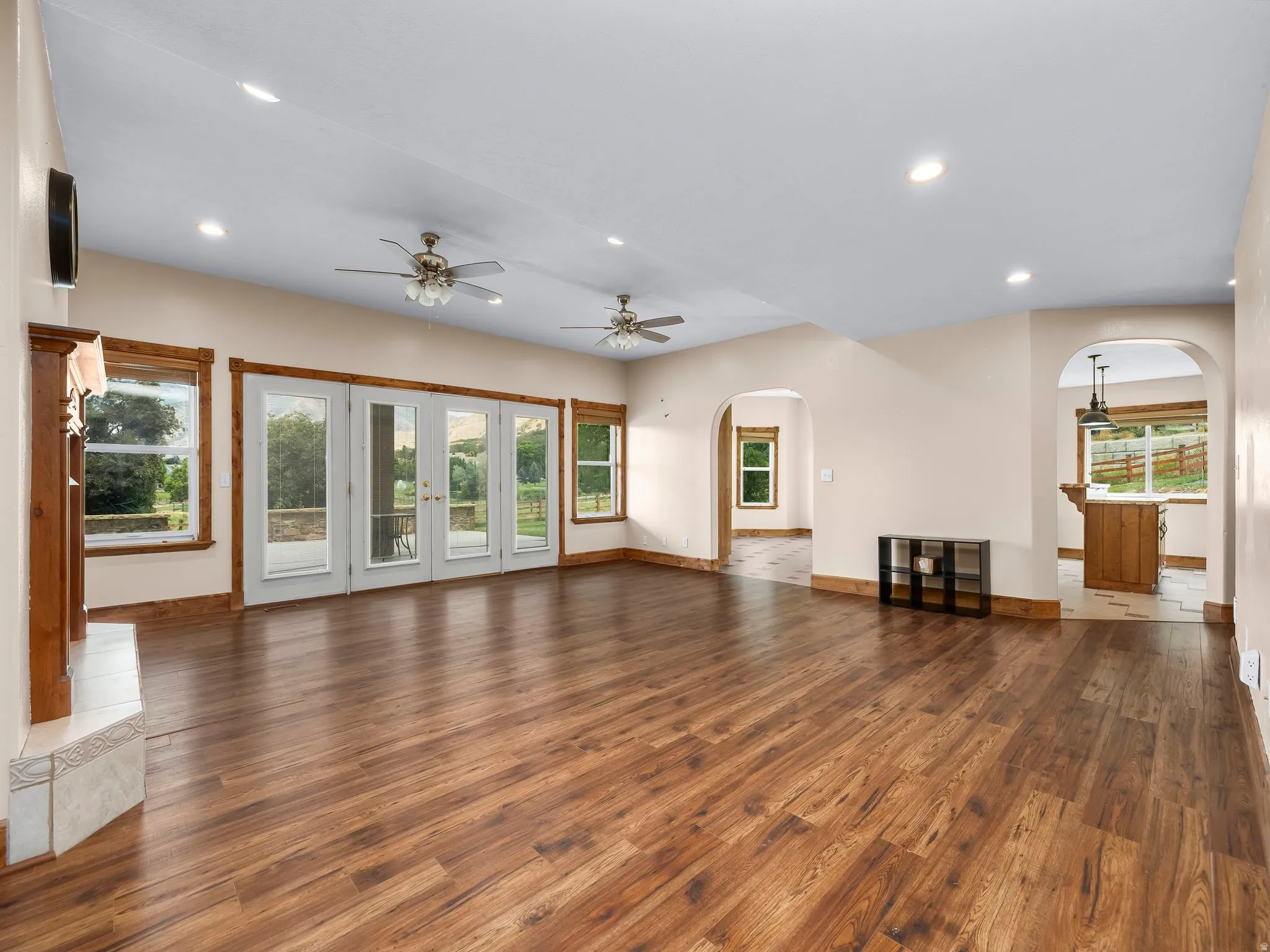 Spacious living area featuring wood-finish flooring, recessed lighting, and ceiling fans