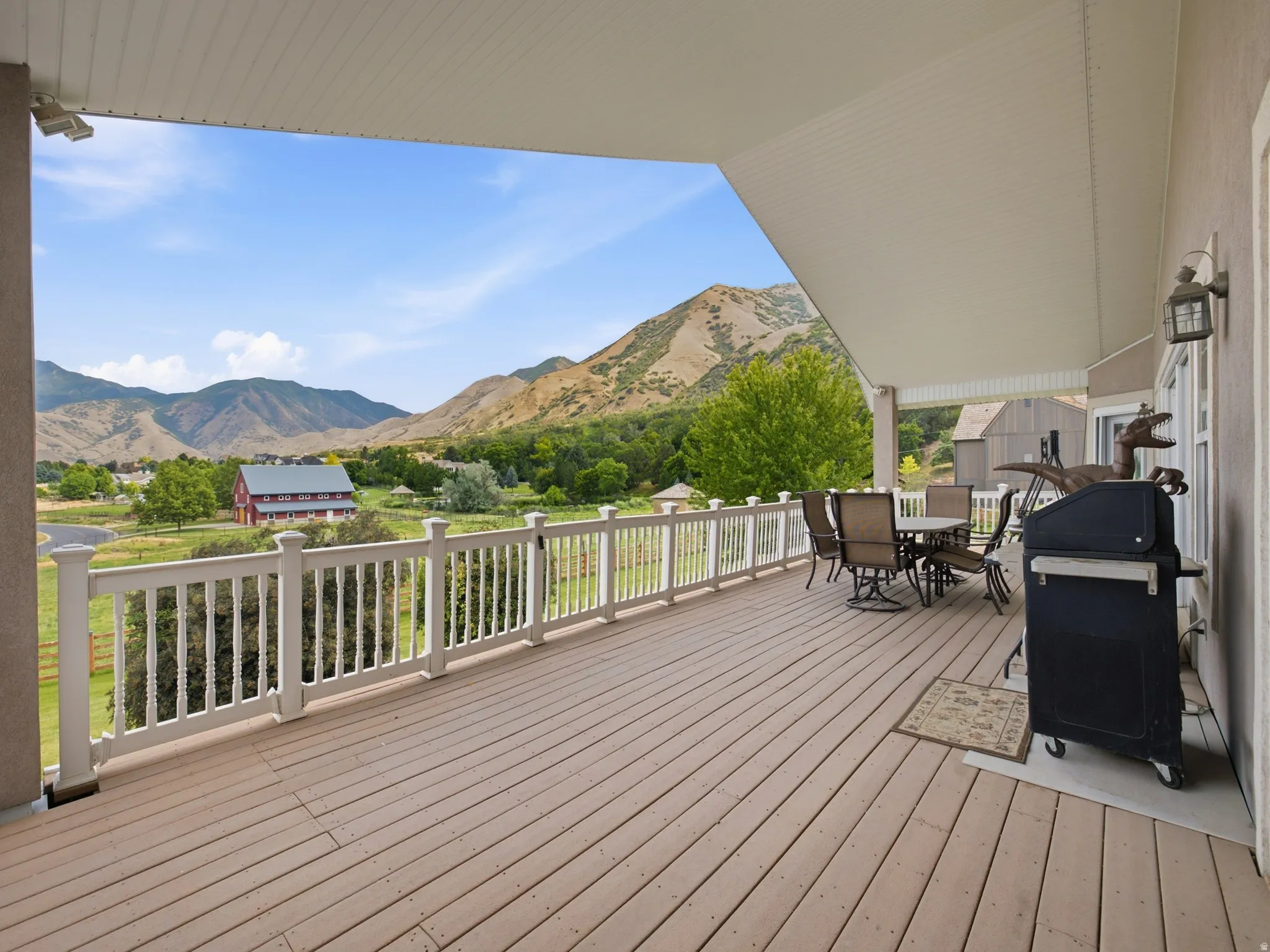 Expansive outdoor deck featuring wood-finish flooring, white railing, and a covered ceiling