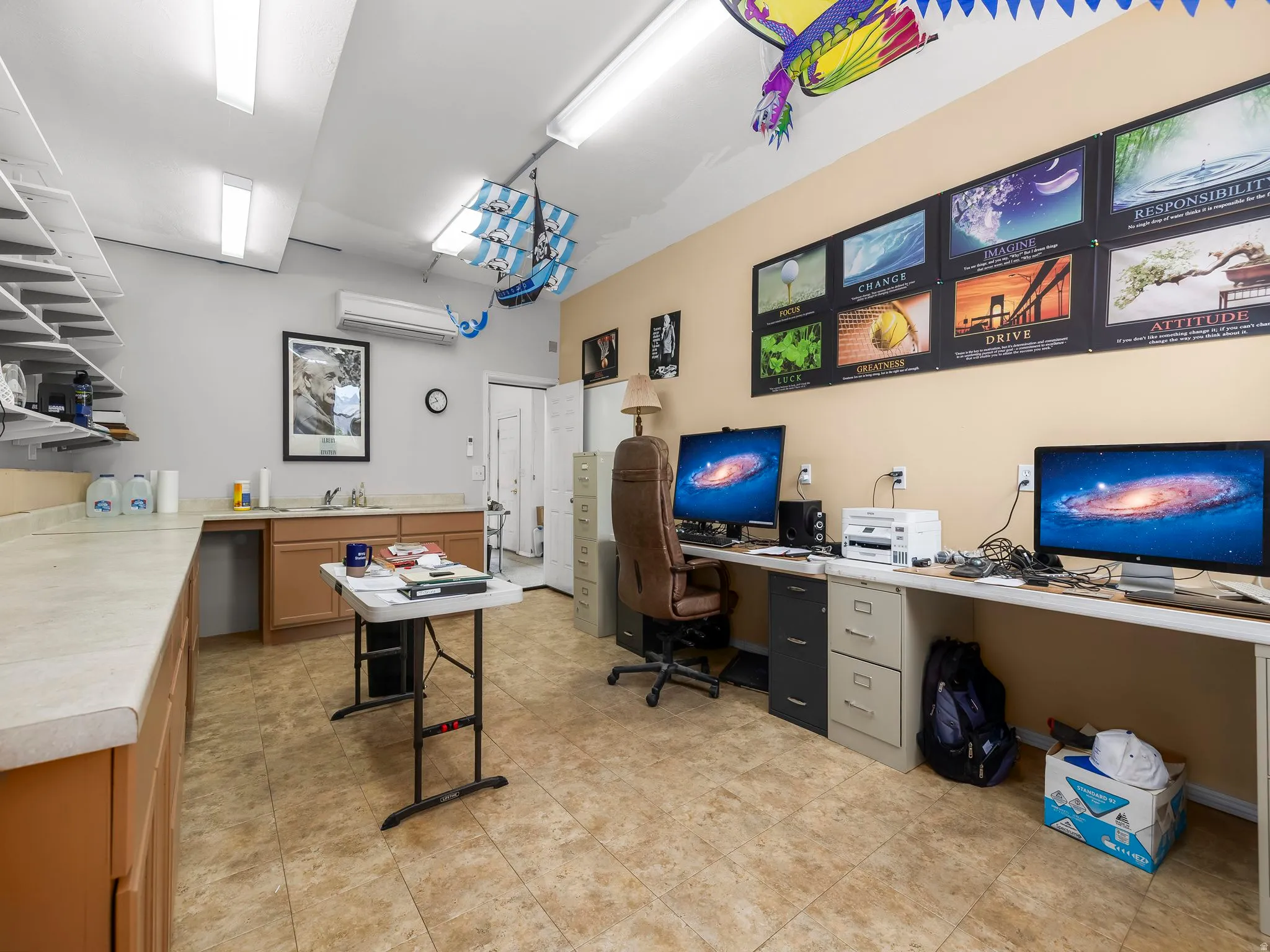 Spacious utility room featuring extensive countertop space, built-in cabinetry, a utility sink, and tiled flooring