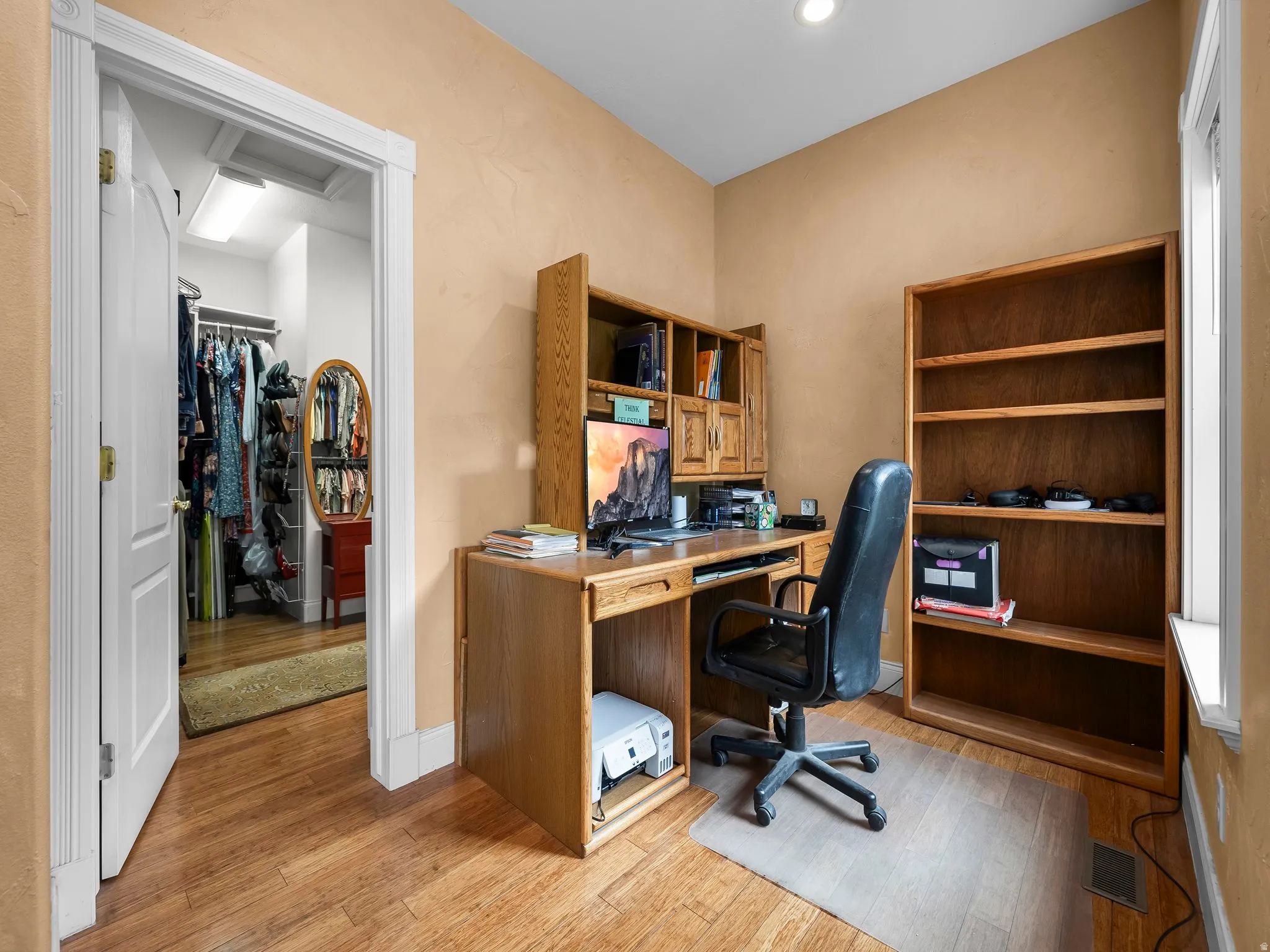 Dedicated room off primary master closet featuring wood-finish flooring, a built-in recessed light, and a window with white trim