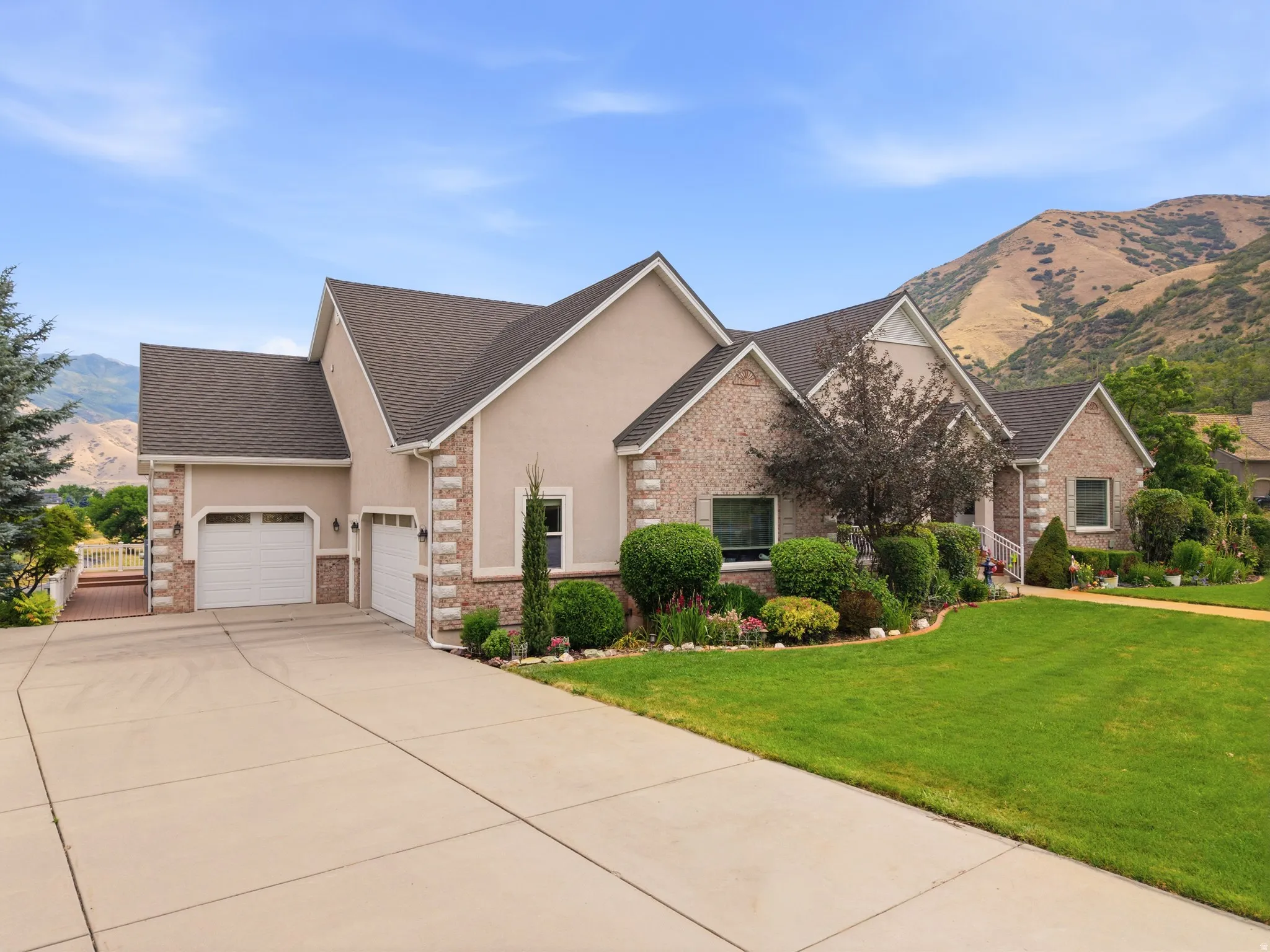 Traditional-style residence featuring a brick and stucco exterior, a two-car garage, and a concrete driveway
