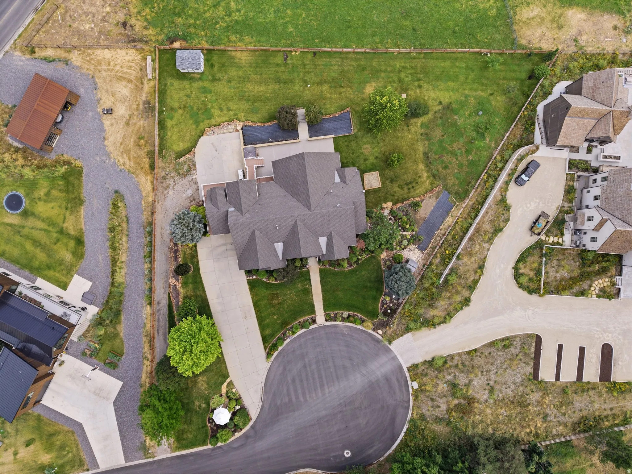 Expansive property featuring a cul-de-sac entrance, a long concrete driveway, and a multi-gabled roofline