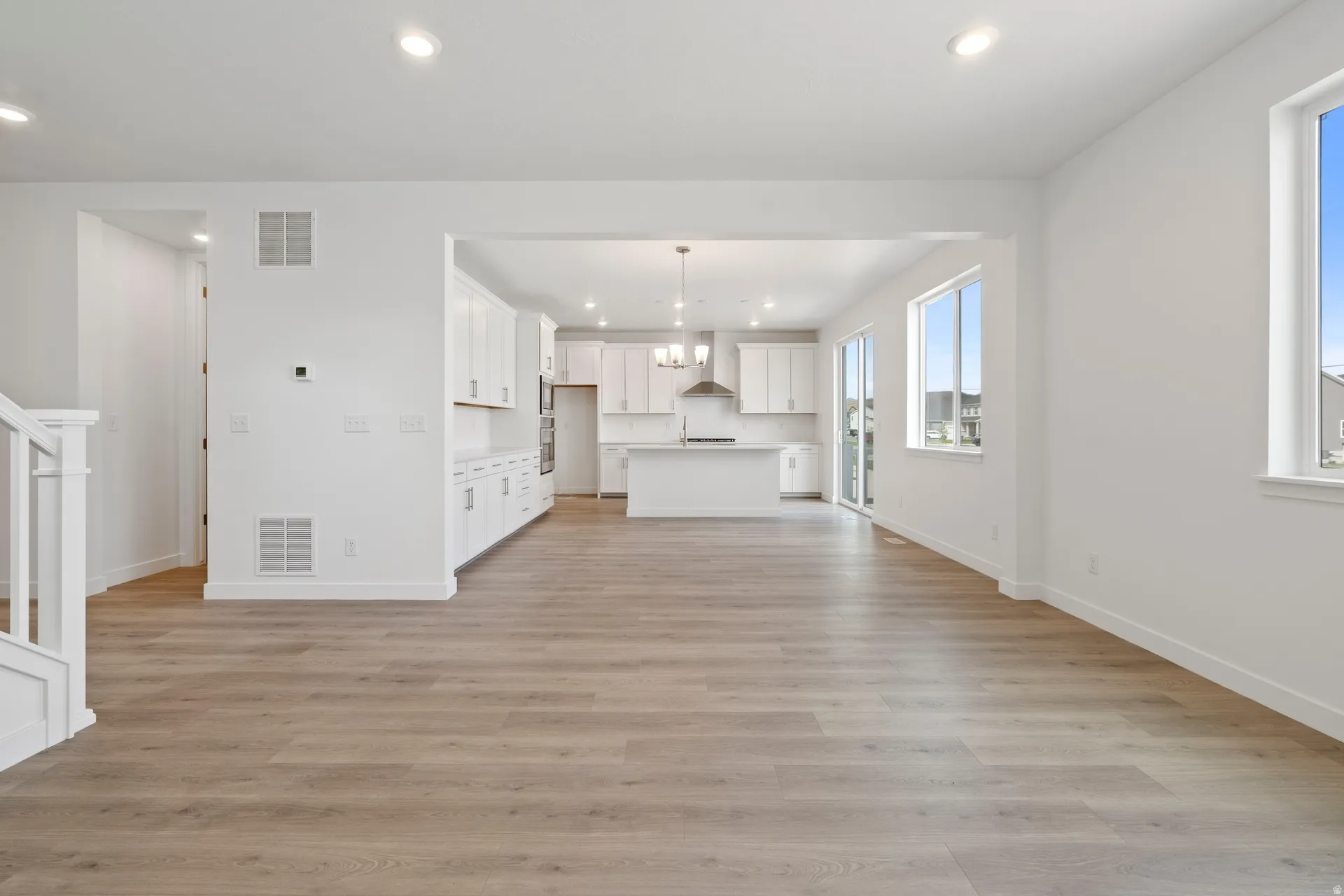 Spacious interior featuring wood-finish flooring, white walls, and recessed lighting